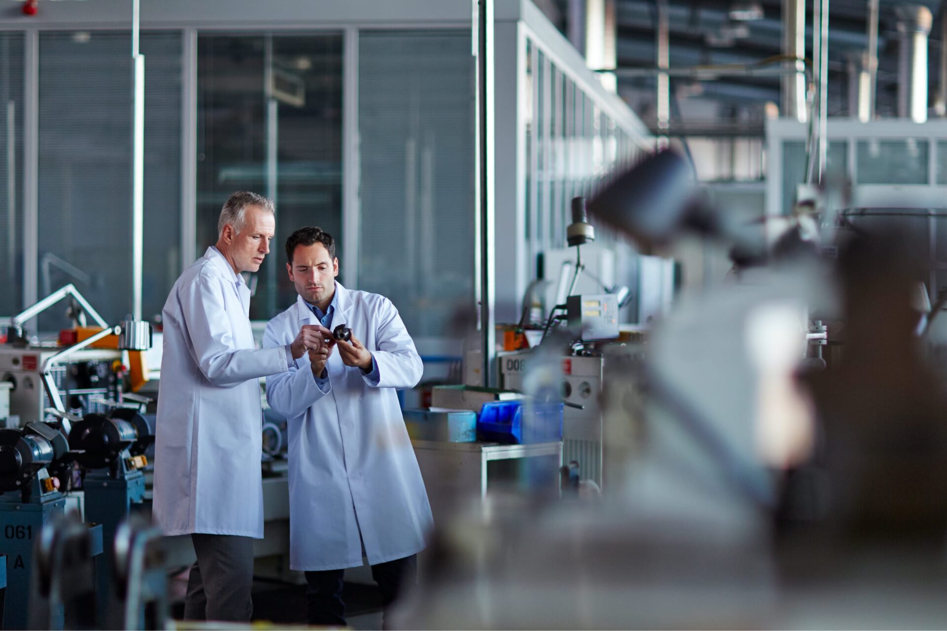 Researchers in lab coats talking in a lab